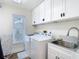 Bright laundry room featuring modern appliances, sink, countertop and storage at 5253 Sandra Dr, Weeki Wachee, FL 34607