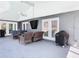 A covered patio includes comfortable wicker furniture, a grill, and multiple doors to the interior at 5253 Sandra Dr, Weeki Wachee, FL 34607
