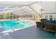 Bright and sunny enclosed pool area featuring a ceiling fan and wicker furniture at 5253 Sandra Dr, Weeki Wachee, FL 34607