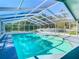 A serene pool enclosed by a white screen, with doors that lead to the interior of the home at 5253 Sandra Dr, Weeki Wachee, FL 34607