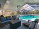 Enclosed pool area with comfortable outdoor seating, ceiling fan, and view of the backyard at 5253 Sandra Dr, Weeki Wachee, FL 34607
