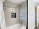 Walk-in shower with gray tile, modern fixtures and recessed niche for storage at 5253 Sandra Dr, Weeki Wachee, FL 34607