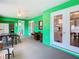 Bright sun room with green walls, tile floors, ceiling fan, and multiple windows for natural light at 5253 Sandra Dr, Weeki Wachee, FL 34607
