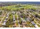 Aerial view of a residential area featuring well-manicured lawns and a nearby golf course with scenic water features at 5303 12Th Avenue W Dr, Bradenton, FL 34209