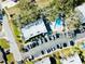 Overhead shot of condo buildings showcasing a pool, parking lot, and surrounding greenery at 700 Lyndhurst St # 1024, Dunedin, FL 34698