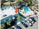 An aerial view of the condo complex featuring a pool, parking area, and lush landscaping at 700 Lyndhurst St # 1024, Dunedin, FL 34698