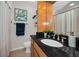 Bathroom features dark countertops, natural wood cabinetry, and a shower/tub combo at 700 Lyndhurst St # 1024, Dunedin, FL 34698