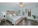 Bedroom featuring calming blue walls, wood floors, and sunny windows at 700 Lyndhurst St # 1024, Dunedin, FL 34698