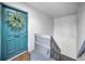 The entrance to the condo features a blue door, a decorative wreath, and nearby stairs at 700 Lyndhurst St # 1024, Dunedin, FL 34698