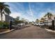 Community entrance featuring wrought iron gates, mature palms and ample parking at 700 Lyndhurst St # 1024, Dunedin, FL 34698