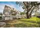 Condo building featuring balconies, lush lawn and mature trees providing shade at 700 Lyndhurst St # 1024, Dunedin, FL 34698