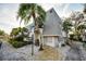 Exterior of the condominium with mature landscaping, palm trees, and ample parking at 700 Lyndhurst St # 1024, Dunedin, FL 34698
