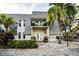 View of the condo's front exterior with a balcony, palm trees, and tidy landscaping at 700 Lyndhurst St # 1024, Dunedin, FL 34698