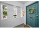 Inviting entryway with teal door, decorative wreath, and side windows offering natural light and a glimpse of the outdoors at 700 Lyndhurst St # 1024, Dunedin, FL 34698