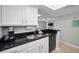 Kitchen view with black countertops, white cabinets, and glimpses of the living area, ideal for entertaining guests at 700 Lyndhurst St # 1024, Dunedin, FL 34698