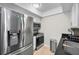 Well-equipped kitchen with stainless steel refrigerator, microwave, and white cabinets, creating a clean cooking space at 700 Lyndhurst St # 1024, Dunedin, FL 34698