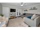Cozy living room features a plush gray sectional, a ceiling fan, and access to the outdoor space at 700 Lyndhurst St # 1024, Dunedin, FL 34698