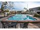 Community pool surrounded by tables and chairs that are near beautiful residential buildings at 700 Lyndhurst St # 1024, Dunedin, FL 34698