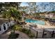 Overhead shot of a pristine community pool, with lush plants, chairs and tables at 700 Lyndhurst St # 1024, Dunedin, FL 34698