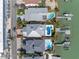 Aerial shot of a home with a pool and dock, nestled among palm trees and other well-kept residences at 8505 Blind Pass Dr, Treasure Island, FL 33706