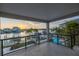 A balcony view overlooking a swimming pool, canal, and sunset creates a serene waterfront living experience at 8505 Blind Pass Dr, Treasure Island, FL 33706