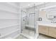 Modern bathroom featuring a glass enclosed shower with bench, sleek vanity, and beautiful neutral pebble flooring at 8505 Blind Pass Dr, Treasure Island, FL 33706