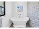 Chic bathroom features a modern soaking tub beneath a window with views of neighborhood buildings at 8505 Blind Pass Dr, Treasure Island, FL 33706