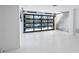 Bright garage with glass brick accent, an open glass panel garage door, and white epoxy floors at 8505 Blind Pass Dr, Treasure Island, FL 33706
