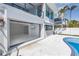 Garage with disappearing doors opens to outdoor pool area; the interior has a mounted tv at 8505 Blind Pass Dr, Treasure Island, FL 33706