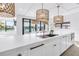Kitchen island features pendant lights, stainless steel appliances, and modern cabinets at 8505 Blind Pass Dr, Treasure Island, FL 33706
