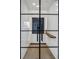 Contemporary wine cellar with a black metal door, wooden floor, and custom bottle storage at 8505 Blind Pass Dr, Treasure Island, FL 33706