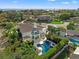 Aerial view of a large luxury home, pool, and outdoor space with tropical landscaping and partial water views at 866 S Davis Blvd, Tampa, FL 33606