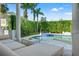 Picturesque view of the pool and landscaping from the covered patio with stylish lounge furniture at 866 S Davis Blvd, Tampa, FL 33606