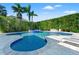 Beautiful pool area features a water feature, mature landscaping and white stone pavers at 866 S Davis Blvd, Tampa, FL 33606