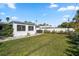 The backyard is green with a white fence and various shrubs along the fence line at 929 Lantana Ave, Clearwater Beach, FL 33767