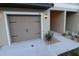 Attached garage featuring tan door with updated black iron hardware and manicured rock landscaping at 11115 Wishing Cloud Rd, Land O Lakes, FL 34638