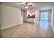 Open-concept living room with tile flooring that flows into an adjoining kitchen and dining area at 11115 Wishing Cloud Rd, Land O Lakes, FL 34638