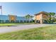 Stunning exterior view of the clubhouse featuring a covered entryway and manicured landscaping at 11439 Golf Round Dr, New Port Richey, FL 34654