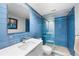 Modern bathroom featuring a glass shower and blue tiled walls at 1200 N Shore Ne Dr # 110, St Petersburg, FL 33701