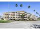 Low angle shot of a multi-story condo building with balconies and palm trees on a sunny day at 1200 N Shore Ne Dr # 110, St Petersburg, FL 33701