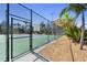 Chain-link fence surrounding a green tennis court with the rules posted and palm trees nearby at 1200 N Shore Ne Dr # 110, St Petersburg, FL 33701