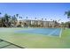 Well-maintained tennis courts with blue and green surfaces, set against a backdrop of a condo building and palm trees at 1200 N Shore Ne Dr # 110, St Petersburg, FL 33701