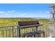 Balcony overlooking a scenic forest and ocean view, furnished with a cozy bar-height table and seating at 12033 Gandy N Blvd # 175, St Petersburg, FL 33702