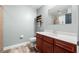 Powder room with cherry vanity, wood-look tile floor, and tiled shower reflected in mirror at 12033 Gandy N Blvd # 175, St Petersburg, FL 33702