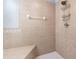 Neutral-toned tiled shower with built-in seat and rainfall showerhead with caddy at 12033 Gandy N Blvd # 175, St Petersburg, FL 33702