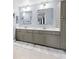Bathroom featuring dual sinks with a gray vanity, neutral tile, large mirrors and great lighting at 12033 Gandy N Blvd # 175, St Petersburg, FL 33702