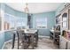 Light-filled dining area with windows, light-blue walls, modern light fixture, wine rack, wooden flooring, and grey dining set at 12033 Gandy N Blvd # 175, St Petersburg, FL 33702
