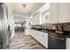 Bright kitchen featuring white cabinets, stainless appliances, black countertop, hexagon backsplash, hardwood flooring, and ample storage at 12033 Gandy N Blvd # 175, St Petersburg, FL 33702