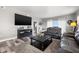 Spacious living room with black leather sofas, hardwood flooring, area rug, neutral walls, and large windows offering natural light at 12033 Gandy N Blvd # 175, St Petersburg, FL 33702