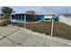 Exterior of the home featuring a lawn, walkway, and screened-in porch at 12734 2Nd Isle, Hudson, FL 34667
